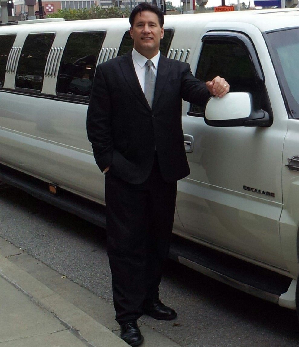 Elite Limousine Chauffeur next to Escalade Limousine